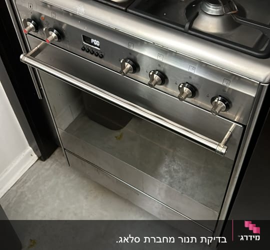 תנור גז עם כפתורים וסירים על הכיריים